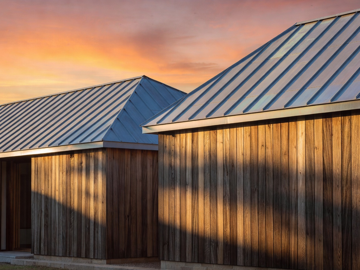 Villa Lumina exterior bathed in sunset light showcasing zinc roof and vertical timber cladding